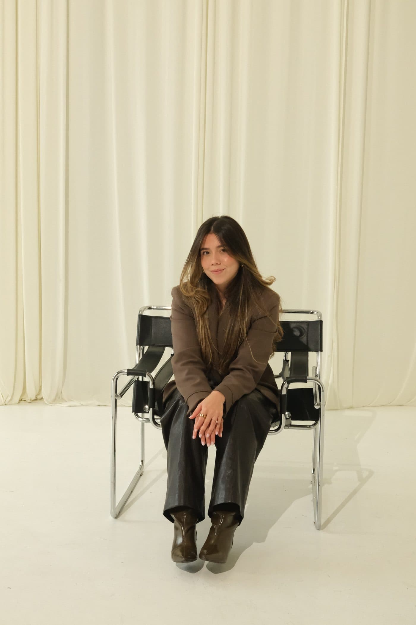Yez, Austin Realtor, seated in a black leather chair